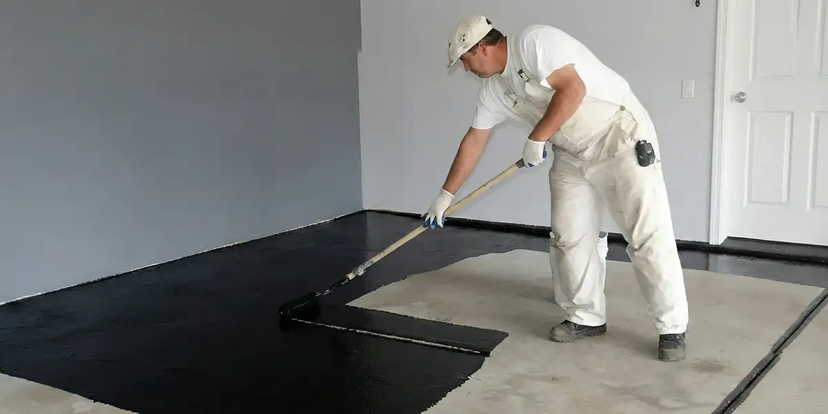 basement waterproofing professional applying waterproof coating to protect a basement floor in Spokane, WA