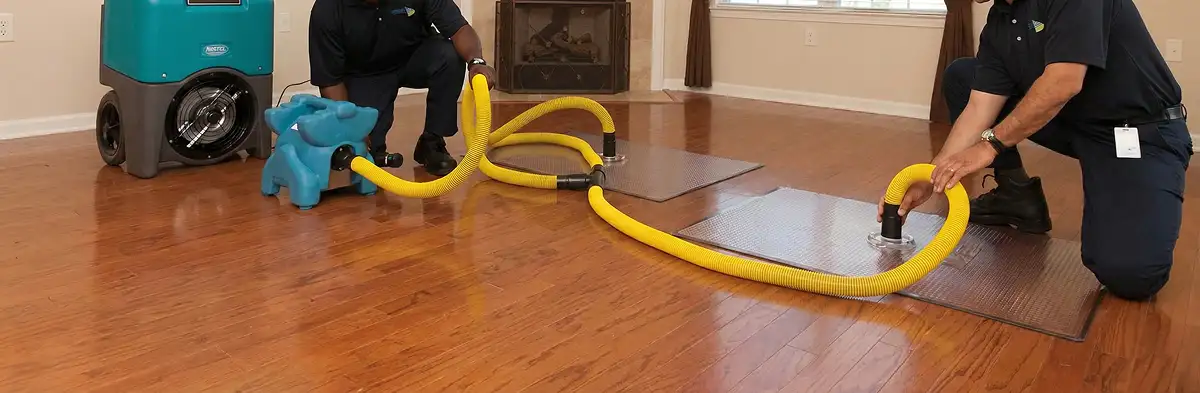 emergency water removal technicians extracting standing water from a home using professional equipment in Spokane, WA